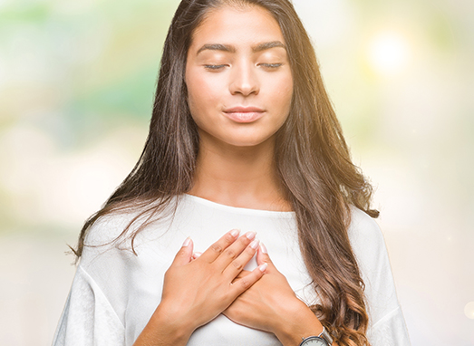 Young beautiful arab woman over isolated background smiling with hands on chest with closed eyes and grateful gesture on face. Health concept.